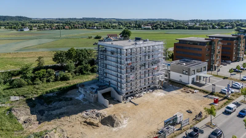 Neubau in Landshut West mit Nachbargebäuden und Feldern im Hintergrund